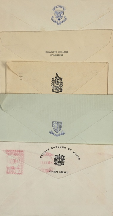 A pile of envelopes from the late 1950s showing pictorial post marks from different academic institutions